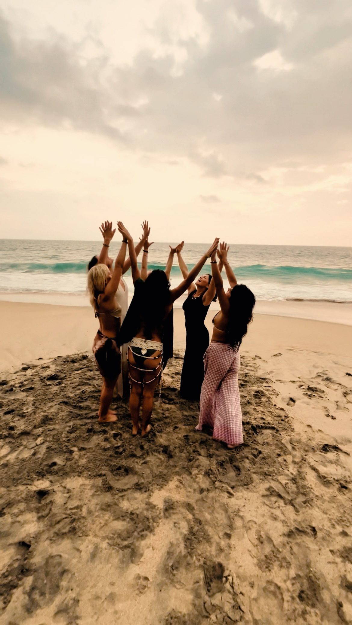 Women at sunset, arms raised